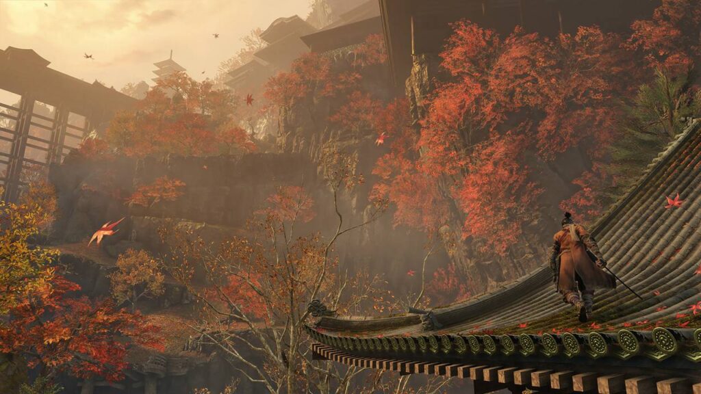 Ein Shinobi läuft über ein Tempeldach, während rote Ahornblätter durch die Luft wirbeln – atmosphärische Herbstszene aus Sekiro: Shadows Die Twice.