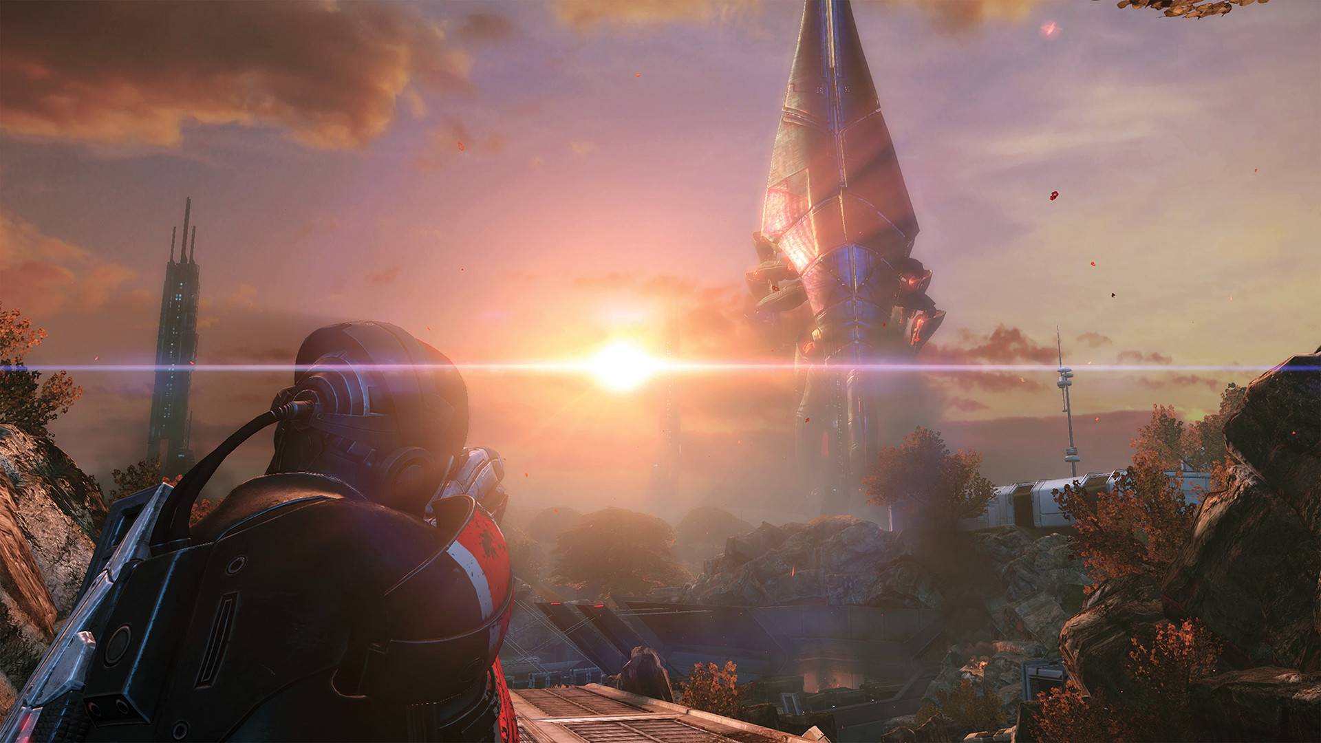 Sci-Fi-Szene aus Mass Effect: Ein Soldat blickt auf eine fremde Landschaft mit riesiger Reaper-Struktur im Sonnenuntergang