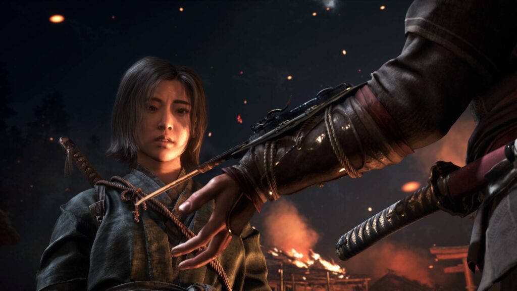 Szene aus Assassin’s Creed Shadows mit zwei Assassinen im feudalen Japan, die sich vor brennender Kulisse gegenüberstehen, während eine Klinge zwischen ihnen gehalten wird.