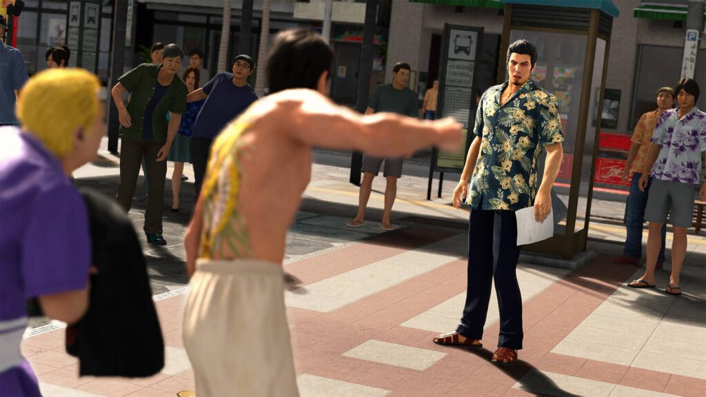 Straßenszene aus Yakuza Kiwami 3: Ein Mann stellt sich in einem öffentlichen Platz einer aggressiven Auseinandersetzung, während Passanten gespannt zuschauen.