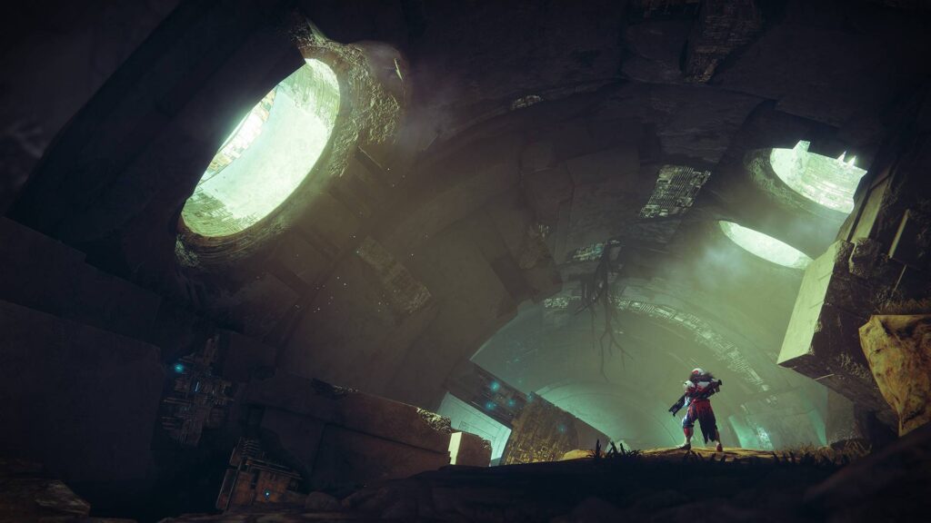 Hüter in Destiny 2 blickt in einer dunklen Ruine auf gewaltige grünlich leuchtende Strukturen.