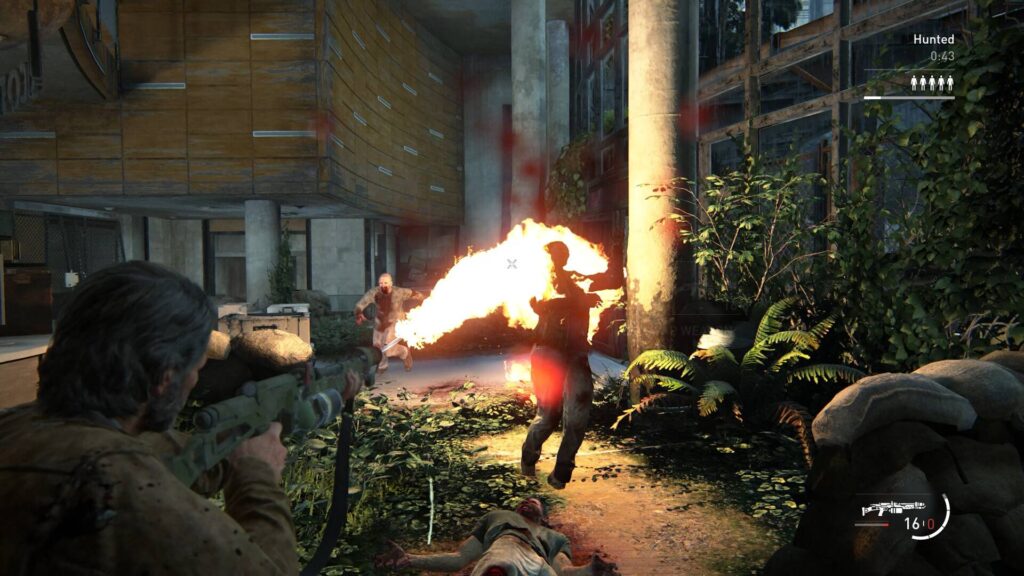 The Last of Us 2 zeigt eine bewaffnete Figur im Feuergefecht gegen Infizierte in einem überwucherten Gebäude.