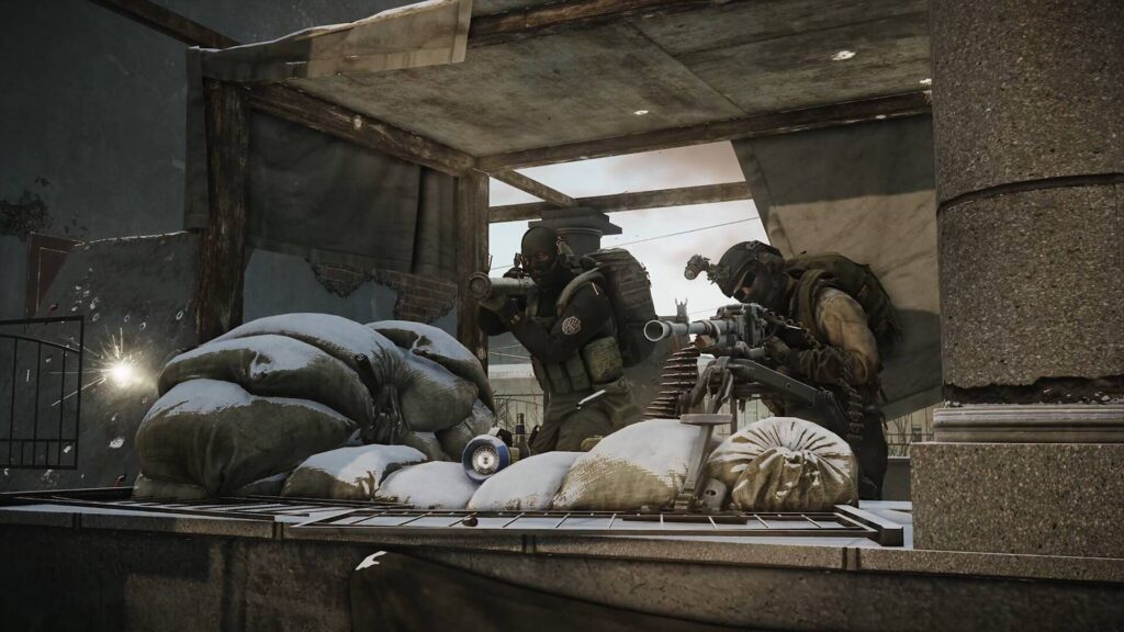 Escape from Tarkov zeigt zwei schwer bewaffnete Kämpfer hinter Sandsäcken, die in einem zerstörten Gebäude Stellung beziehen.