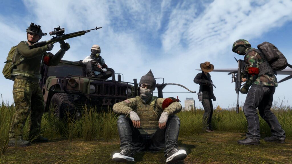 DayZ zeigt eine Gruppe bewaffneter Überlebender mit Fahrzeug auf einer Wiese unter hellem Himmel.