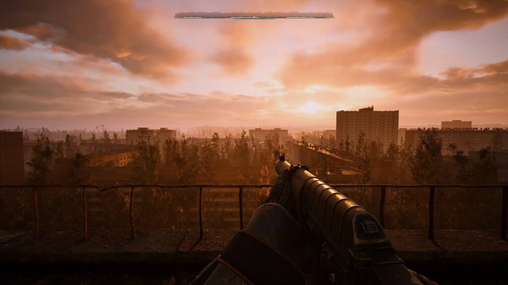 Stalker 2 zeigt eine Waffe aus der Ego-Perspektive auf einem Dach mit Blick über eine verlassene Stadt im orangefarbenen Sonnenuntergang.