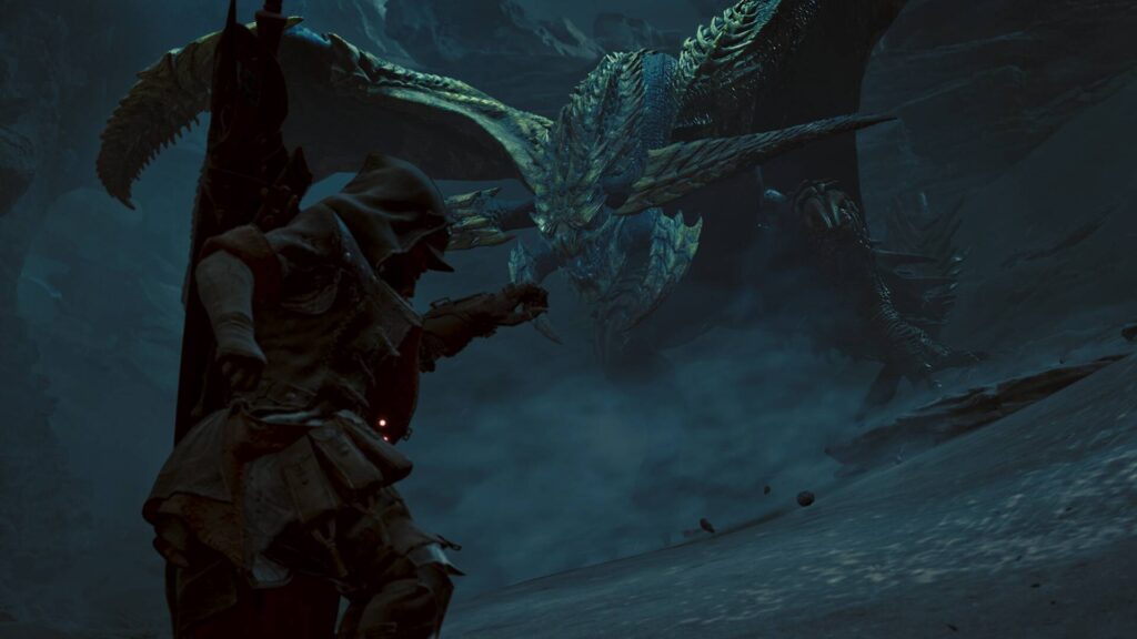 Ein Jäger stellt sich in Monster Hunter Wilds einem gewaltigen geflügelten Drachen in einer dunklen Höhle.