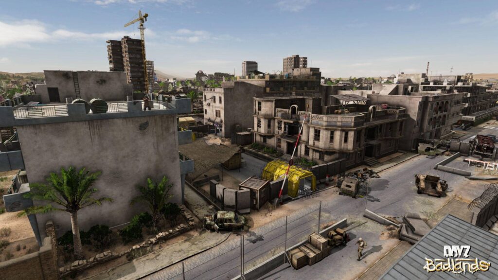 Abgesperrter Militärposten mit Fahrzeugen, Versorgungskisten und einem gelben Zelt in DayZ Badlands.